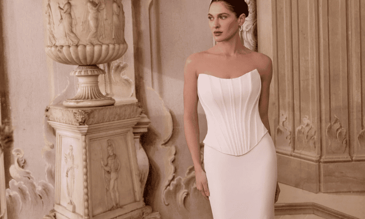 Bride wearing a strapless white wedding dress with a structured corset bodice and fitted silhouette in an elegant interior.
